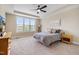 Bedroom with large window, ceiling fan, neutral carpet, and a full bed with side tables at 1905 Cedar Dam Ln, Wendell, NC 27591