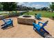 Inviting fire pit area with stone seating and Adirondack chairs, perfect for cozy evenings with friends and Gathering at 1905 Cedar Dam Ln, Wendell, NC 27591