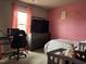 Cozy bedroom featuring a pink accent wall, a large television, and comfortable furnishings at 194 Cornfield Ln, Benson, NC 27504
