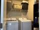 Functional laundry room with washer, dryer, and storage shelves at 194 Cornfield Ln, Benson, NC 27504