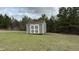 Outdoor storage building with white doors and a brown roof on a green lawn at 194 Cornfield Ln, Benson, NC 27504