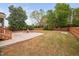 Backyard with patio, firepit, Adirondack chairs, lawn, trees, and wooden fence at 2001 Lilly Brook St, Fuquay Varina, NC 27526