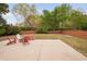 Backyard patio with a fire pit and Adirondack chairs, surrounded by a lawn, trees, and a wooden fence at 2001 Lilly Brook St, Fuquay Varina, NC 27526