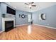 Spacious living room with hardwood floors, fireplace, ceiling fan, and large television at 2001 Lilly Brook St, Fuquay Varina, NC 27526