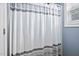 Bathroom features a decorative gray and white striped shower curtain at 2001 Lilly Brook St, Fuquay Varina, NC 27526