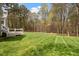 Lush backyard area featuring a large manicured lawn area with mature trees, a deck and stairs at 2321 Mica Mine Ln, Wake Forest, NC 27587