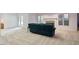 Spacious basement area with carpet flooring and a comfortable teal couch near the fireplace at 2321 Mica Mine Ln, Wake Forest, NC 27587