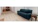 Spacious carpeted basement with a comfortable teal couch, study area, and side table at 2321 Mica Mine Ln, Wake Forest, NC 27587