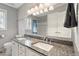 Bright bathroom featuring dual sinks, granite countertop, and large mirror with decorative lighting at 2321 Mica Mine Ln, Wake Forest, NC 27587