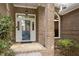 Inviting front porch with brick facade, decorative pillars, and glass accented door at 2321 Mica Mine Ln, Wake Forest, NC 27587