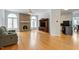 Open living room with hardwood floors, a brick fireplace, a tv cabinet, and access to the kitchen at 2321 Mica Mine Ln, Wake Forest, NC 27587