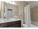 Bathroom featuring a shower-tub combo, dark cabinets, cream walls, a white porcelain toilet, and brushed nickel fixtures at 2421 Trenton Park Ln, Raleigh, NC 27607