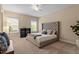 Comfortable bedroom featuring neutral tones, carpet floors, a tufted headboard and bright windows at 2421 Trenton Park Ln, Raleigh, NC 27607
