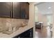 Butler pantry with granite counters, decorative hardware and views into adjacent living area at 2421 Trenton Park Ln, Raleigh, NC 27607