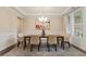 Bright dining room with elegant chandelier, large window, and neutral-toned rug at 2421 Trenton Park Ln, Raleigh, NC 27607