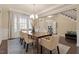 Stylish dining room with large window, chandelier, hardwood floors, and neutral decor at 2421 Trenton Park Ln, Raleigh, NC 27607