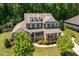 Beautiful aerial view of a two-story brick home with a well-manicured lawn, shrubs, and trees at 2421 Trenton Park Ln, Raleigh, NC 27607