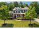 Beautiful two-story brick home featuring a lush green lawn and mature trees at 2421 Trenton Park Ln, Raleigh, NC 27607