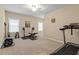 Spacious home gym with treadmill, weight rack, mounted art and neutral color carpet at 2421 Trenton Park Ln, Raleigh, NC 27607