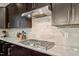 Modern kitchen with stainless gas cooktop, granite backsplash, and ample counter space at 2421 Trenton Park Ln, Raleigh, NC 27607