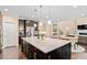 Large kitchen island featuring granite countertop, ample storage and views into adjacent living area at 2421 Trenton Park Ln, Raleigh, NC 27607
