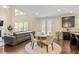 Open-concept living area with ample natural light, hardwood floors, fireplace, and dining space at 2421 Trenton Park Ln, Raleigh, NC 27607