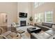 Well-lit living room featuring a fireplace, two-story ceilings, and a window at 2421 Trenton Park Ln, Raleigh, NC 27607