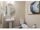 Well-lit powder room featuring a pedestal sink, a round mirror, and tasteful wall art at 2421 Trenton Park Ln, Raleigh, NC 27607