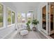 Sunroom with plank walls, a light gray accent chair, a cushioned ottoman, and large windows that look out onto the backyard at 2421 Trenton Park Ln, Raleigh, NC 27607