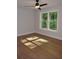 Sunlit bedroom with hardwood floors, neutral walls, and a large window with green, wooded views at 245 Marilyn Cir, Cary, NC 27513