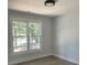 Bedroom featuring hardwood floors, modern ceiling light, and large window with wooded views at 245 Marilyn Cir, Cary, NC 27513
