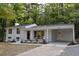 A charming single-Gathering home featuring a white exterior, a covered carport, and a well-manicured lawn with mature trees at 245 Marilyn Cir, Cary, NC 27513