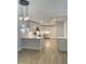 Kitchen with stainless steel appliances, white cabinets, gray walls, wood floors, a small window, and modern globe pendant lights at 245 Marilyn Cir, Cary, NC 27513