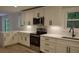 Modern kitchen features white cabinets, quartz countertops, stainless appliances, and a stylish backsplash at 245 Marilyn Cir, Cary, NC 27513