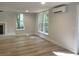 Bright living room boasting wood floors, mini-split AC unit, and natural light from multiple windows at 245 Marilyn Cir, Cary, NC 27513