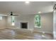 A spacious living room featuring wood floors, a fireplace, and windows that illuminate the bright interior at 245 Marilyn Cir, Cary, NC 27513