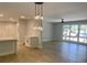 Open concept living space featuring wood floors, recessed lights, a modern pendant light fixture, and large windows at 245 Marilyn Cir, Cary, NC 27513