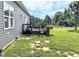View of a well maintained backyard with a rustic deck, seating, grill, and lush green lawn at 2540 Levi Ln, Bahama, NC 27503