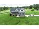 Charming grey home boasts a well manicured lawn, attached two car garage, and lush landscaping at 2540 Levi Ln, Bahama, NC 27503