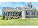 Charming gray home featuring a welcoming front porch, landscaped yard, and stylish architectural details at 2540 Levi Ln, Bahama, NC 27503