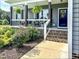 Charming front porch with black columns, white railings, hanging ferns, and a deep blue door at 2540 Levi Ln, Bahama, NC 27503