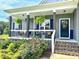 Charming front porch with hanging ferns, rocking chairs, black shutters, and a well-manicured garden at 2540 Levi Ln, Bahama, NC 27503