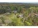 An aerial view showcases the lush surrounding trees of the property in a tranquil, wooded setting at 2920 Ode Turner Rd, Hillsborough, NC 27278