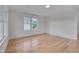 Well-lit bedroom with hardwood flooring, white trim, and a large window overlooking the yard at 301 E Umstead St, Durham, NC 27707