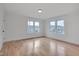 Bright bedroom featuring hardwood floors and multiple windows for ample natural light at 301 E Umstead St, Durham, NC 27707