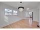 Dining space featuring a modern chandelier, hardwood floors, and an open transition to the kitchen at 301 E Umstead St, Durham, NC 27707