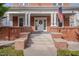 Inviting front porch with classic columns and brick accents, perfect for relaxing and enjoying the outdoors at 301 E Umstead St, Durham, NC 27707