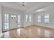 Open living room with hardwood floors, decorative lighting, white trim, and a glass front door at 301 E Umstead St, Durham, NC 27707