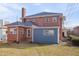 A two-story brick home with a detached one-story blue structure; a brick chimney and dry grass complete the scene at 301 E Umstead St, Durham, NC 27707