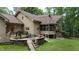 The backyard features an elevated wood deck, stone pavers, green grass, and a lush green forest at 301 Stone Currie Dr, Hillsborough, NC 27278